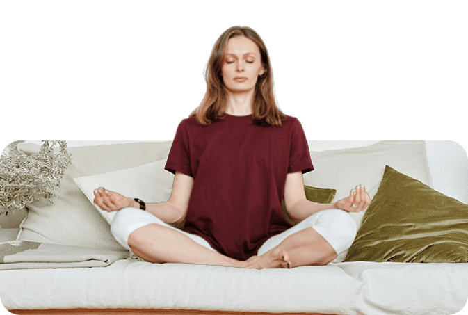 A woman sitting on top of a couch in the middle of her meditation.