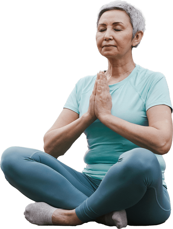 A woman sitting in the middle of her yoga class.