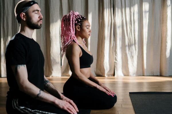 A man and woman sitting in the lotus position.