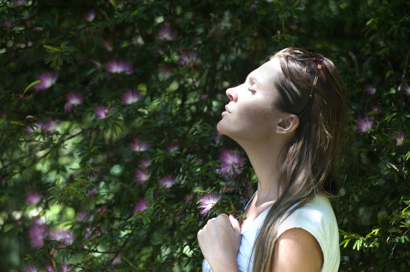 A woman is standing in front of some bushes